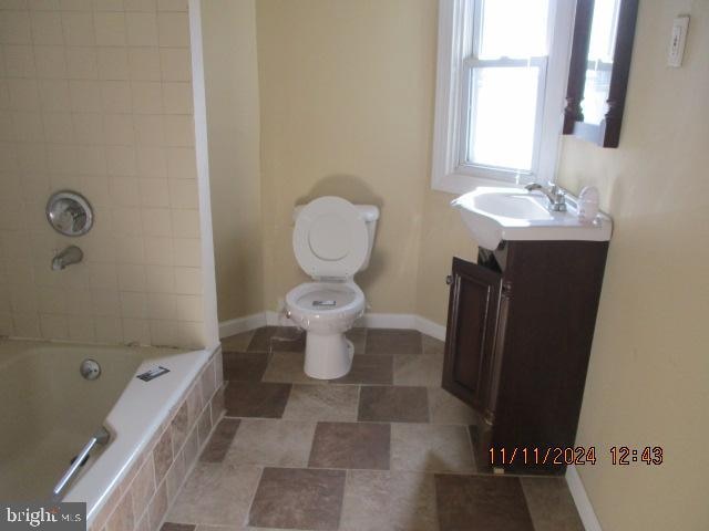 full bathroom with vanity, toilet, and tiled shower / bath combo