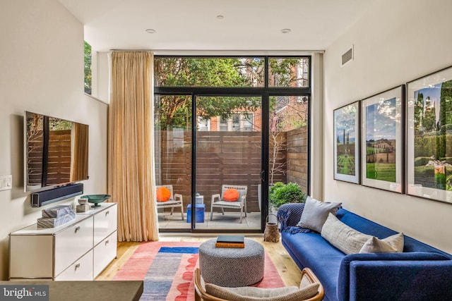 entryway with light wood-style flooring, expansive windows, and visible vents