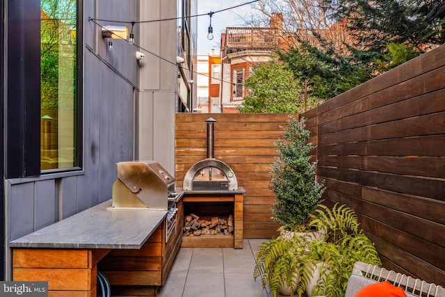 view of patio with a grill, fence, and area for grilling