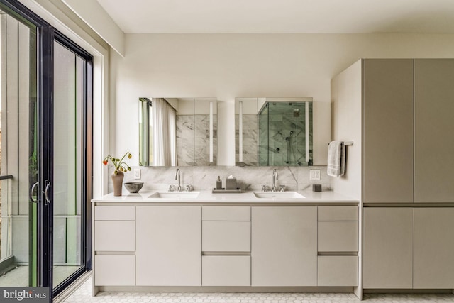 bathroom with a sink, backsplash, a shower stall, and double vanity