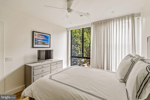 bedroom with baseboards, a ceiling fan, and wood finished floors