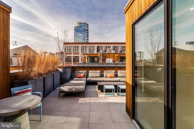 balcony featuring a patio area, outdoor lounge area, and a city view