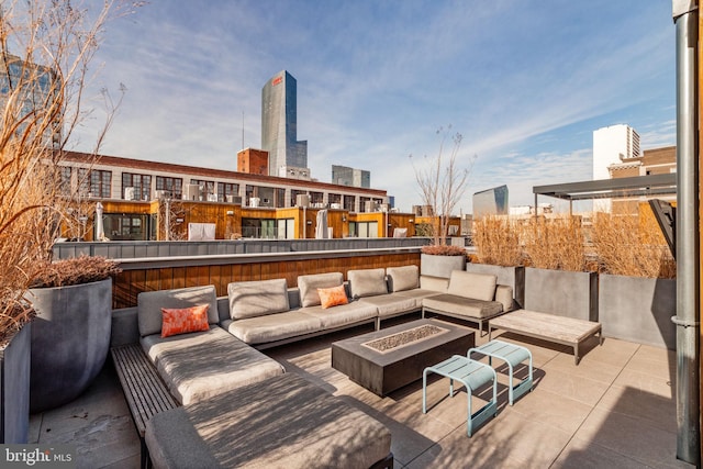 view of patio / terrace with a city view and an outdoor living space with a fire pit