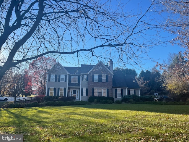 colonial-style house featuring a front lawn