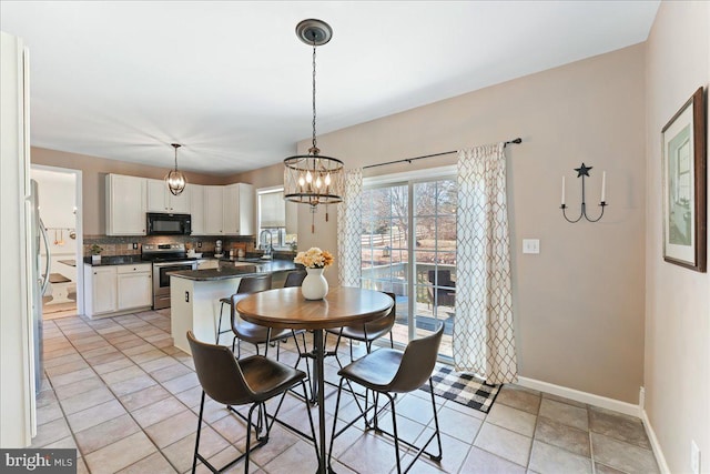 tiled dining area featuring sink and a notable chandelier