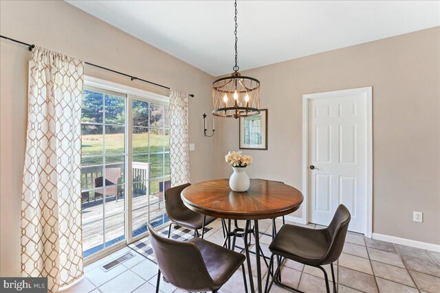 tiled dining area featuring an inviting chandelier