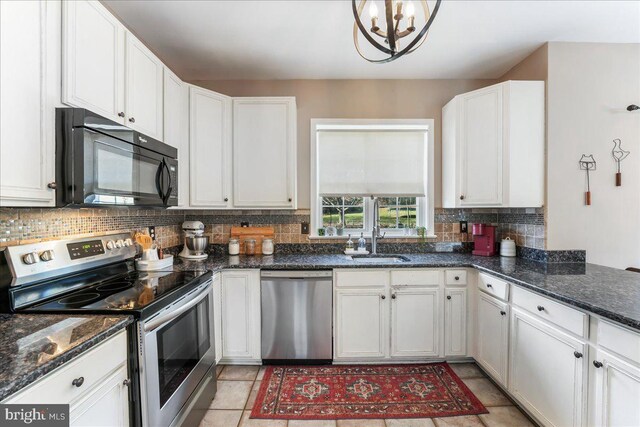 kitchen with decorative backsplash, appliances with stainless steel finishes, sink, a chandelier, and white cabinetry