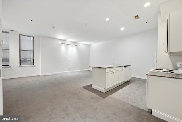 kitchen with white cabinetry, white dishwasher, and light colored carpet