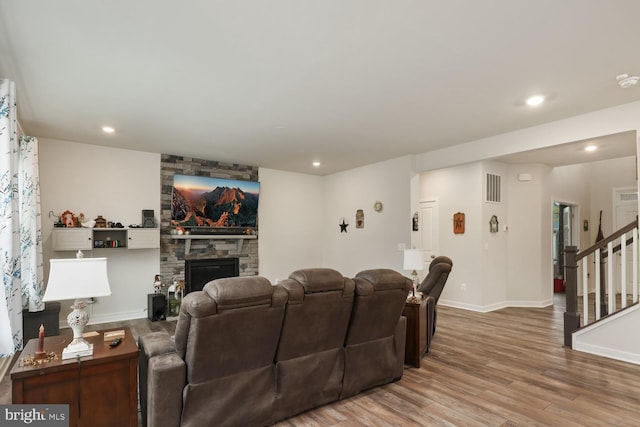 cinema room featuring recessed lighting, a fireplace, wood finished floors, visible vents, and baseboards