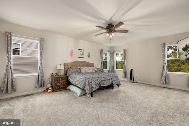 carpeted bedroom featuring visible vents, baseboards, and a ceiling fan