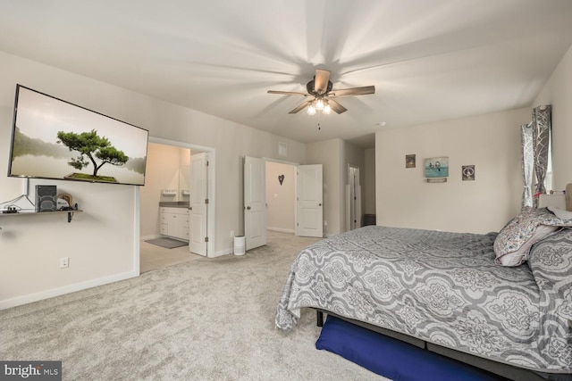 bedroom featuring light carpet, ceiling fan, ensuite bathroom, and baseboards