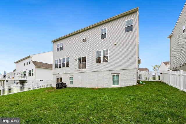 rear view of house with a yard and a fenced backyard