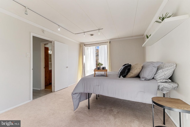 carpeted bedroom featuring rail lighting and ornamental molding