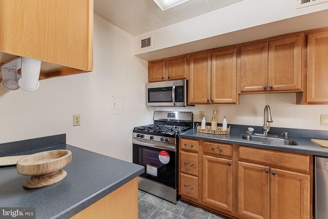 kitchen with appliances with stainless steel finishes, light tile patterned floors, and sink