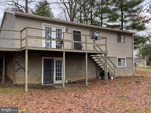 rear view of property with a wooden deck and french doors