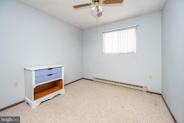 carpeted spare room featuring baseboard heating and ceiling fan