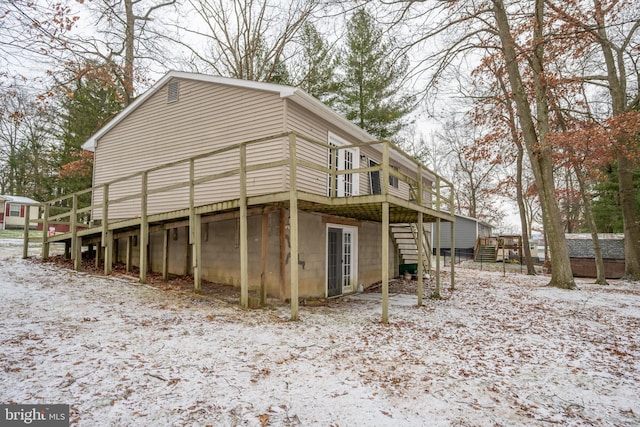 view of snowy exterior featuring a deck