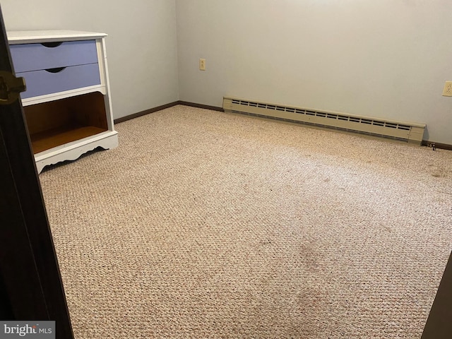 unfurnished room with carpet flooring and a baseboard radiator