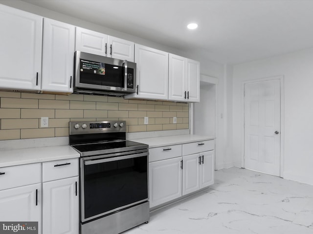 kitchen with tasteful backsplash, white cabinetry, and appliances with stainless steel finishes