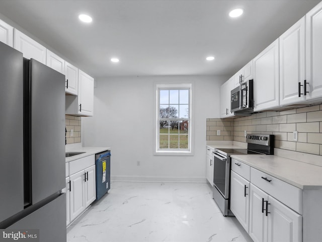 kitchen with backsplash, white cabinets, and stainless steel appliances