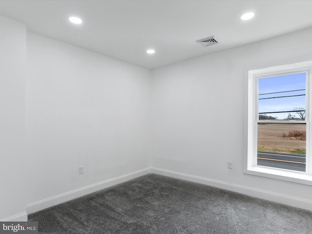 empty room featuring dark colored carpet