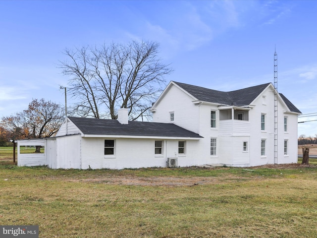 rear view of house featuring a lawn and ac unit