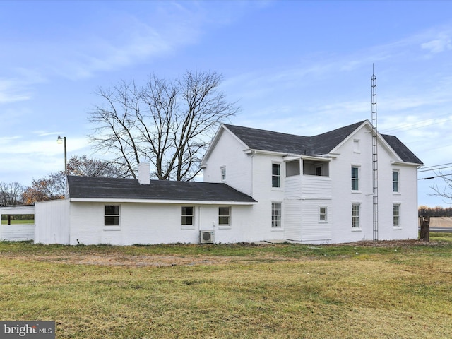 rear view of house featuring a lawn and ac unit