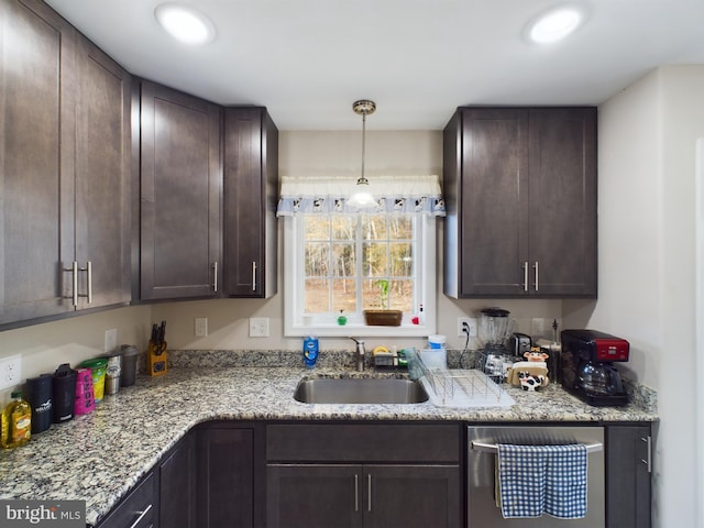 kitchen with sink, stainless steel dishwasher, decorative light fixtures, light stone counters, and dark brown cabinetry