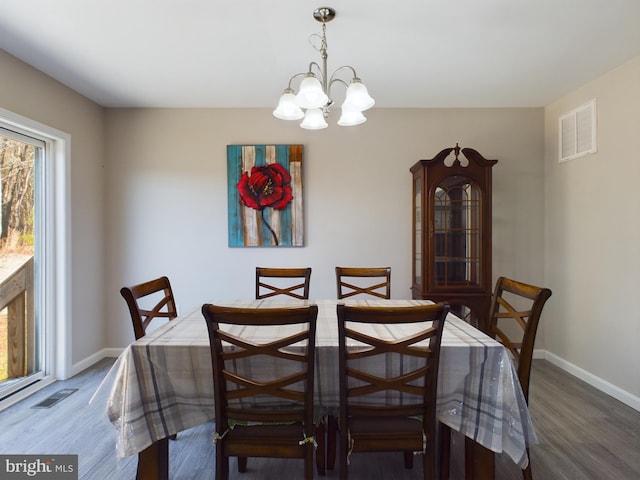 dining space with an inviting chandelier and dark wood-type flooring