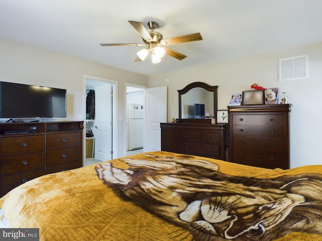 bedroom featuring ceiling fan, a spacious closet, connected bathroom, white fridge, and a closet