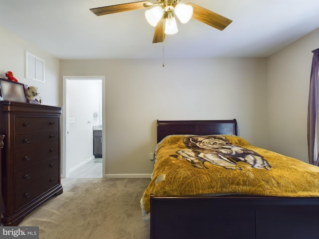 carpeted bedroom with ensuite bath and ceiling fan