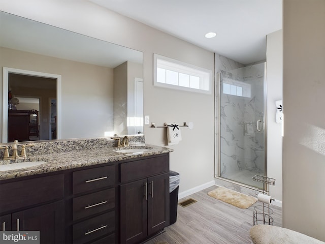 bathroom featuring hardwood / wood-style floors, vanity, and walk in shower