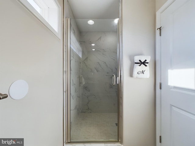 bathroom with a shower with door