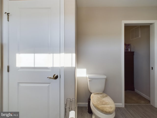 bathroom featuring wood-type flooring and toilet