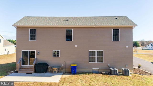 rear view of property featuring a lawn, cooling unit, and a patio