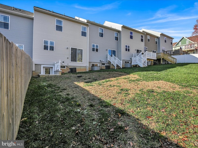 back of property featuring a yard and a wooden deck