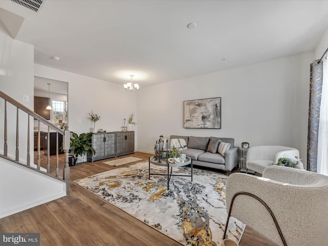 living room with wood-type flooring and an inviting chandelier