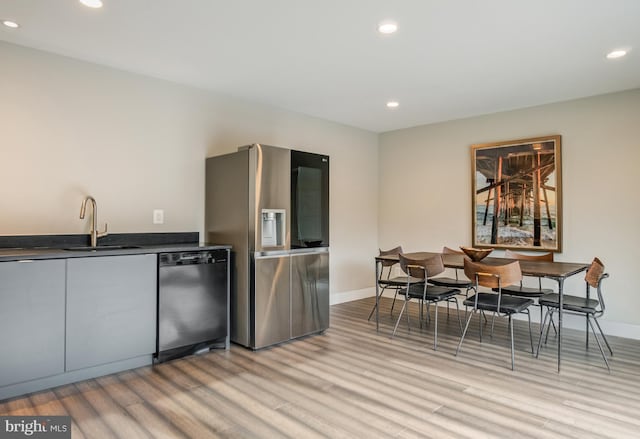 kitchen featuring stainless steel appliances, light hardwood / wood-style floors, and sink