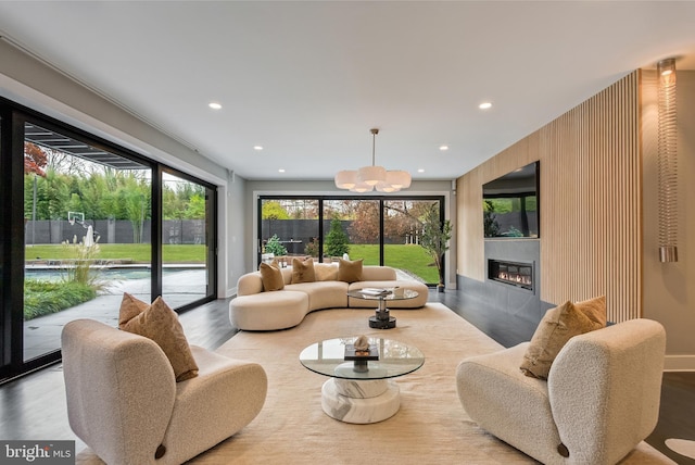 living room featuring light hardwood / wood-style flooring, a healthy amount of sunlight, and an inviting chandelier