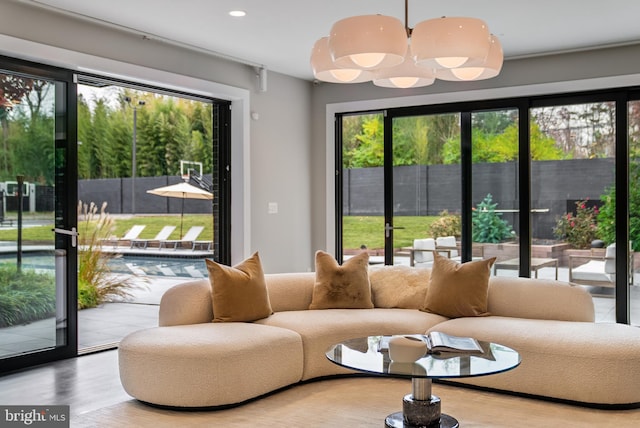 living room with hardwood / wood-style flooring, a wealth of natural light, and a notable chandelier