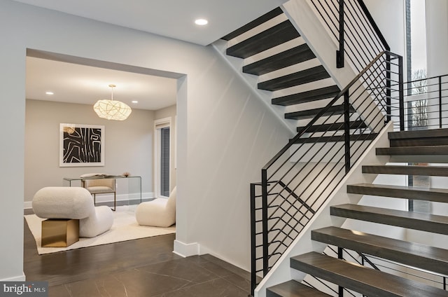 stairs featuring tile patterned flooring and a chandelier