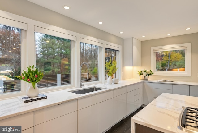 kitchen featuring white cabinetry, sink, and a wealth of natural light