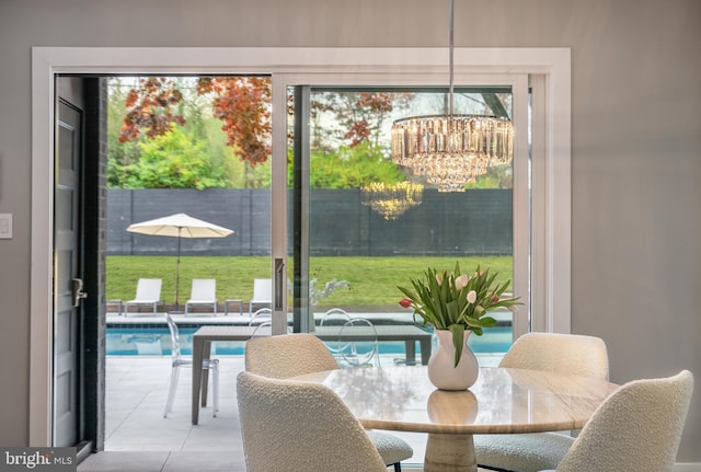 tiled dining room with a chandelier