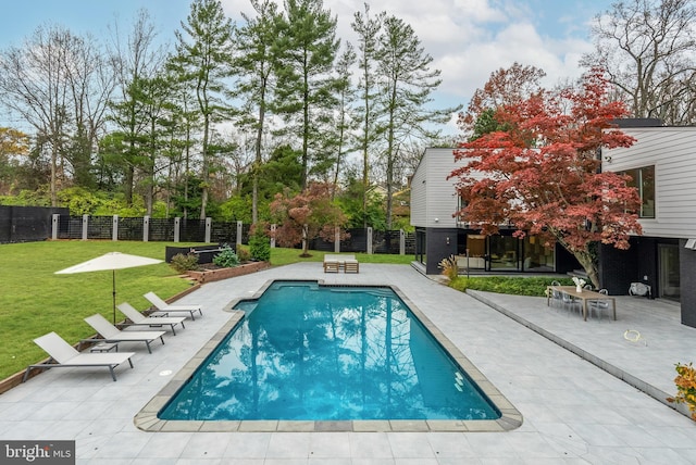 view of pool featuring a lawn and a patio area