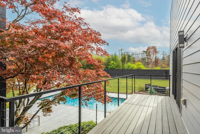 wooden terrace with a fenced in pool and a yard