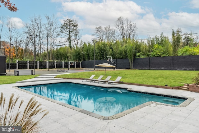 view of pool with a patio area and a yard