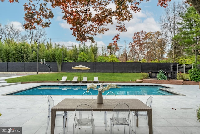 view of swimming pool with a yard