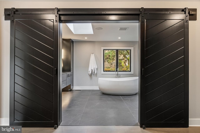 bathroom featuring a bathtub, vanity, and a skylight