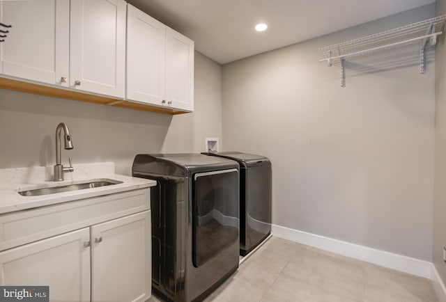 washroom featuring sink, light tile patterned flooring, cabinets, and independent washer and dryer