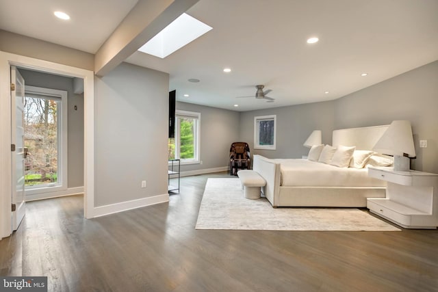 bedroom with a skylight, wood-type flooring, and multiple windows